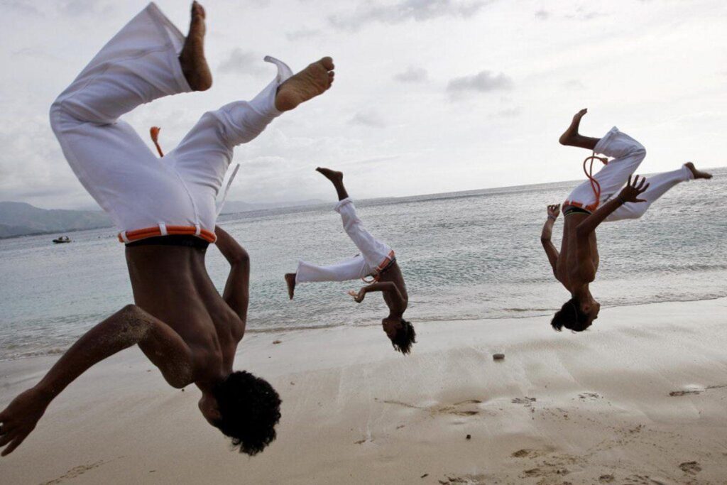 A group of men practice capoeira on the beach in Dili wallpapers
