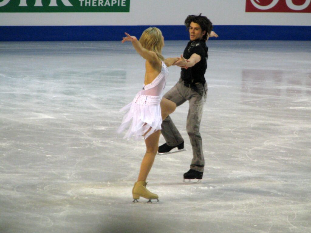Woman and man ice skating free Wallpaper