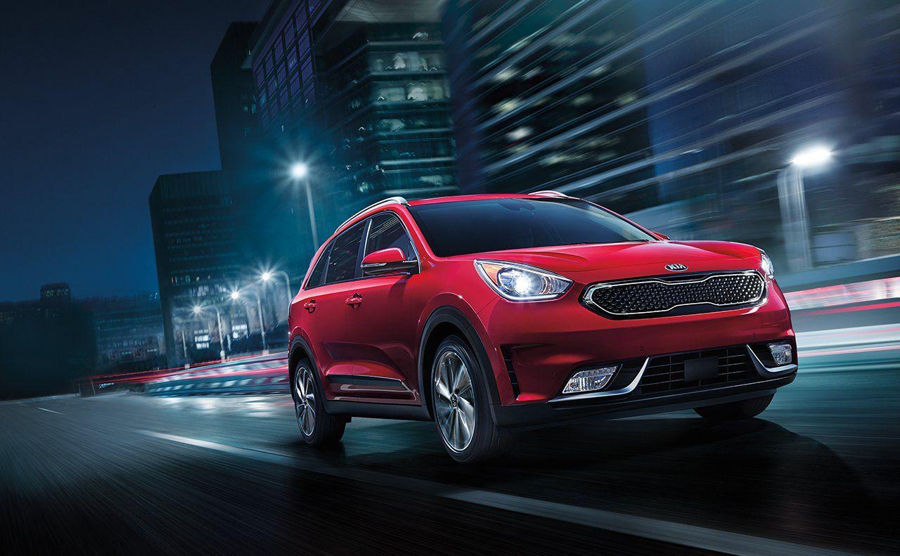 Kia Niro EV red color night on road in city lights backgrounds